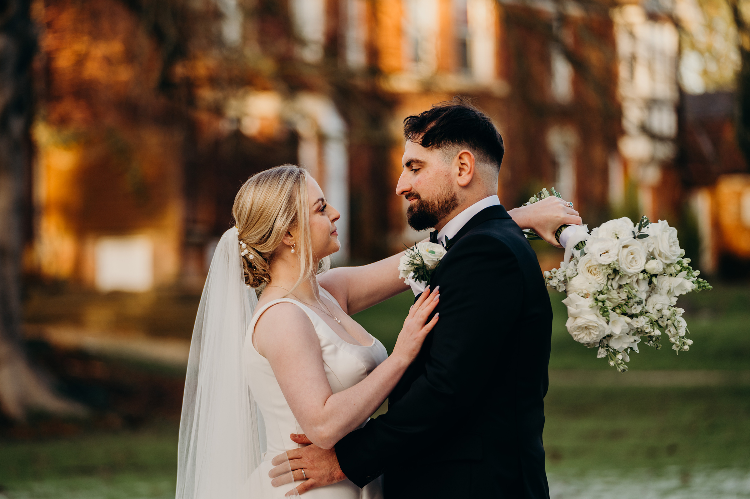 Bride and groom stood facing each other infront of wedding venue